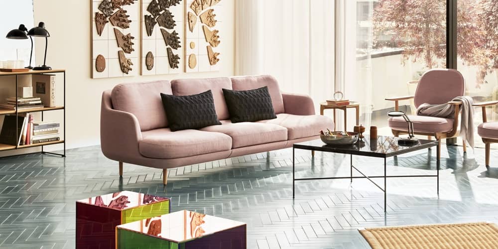 In einem Wohnzimmer sind unterschiedliche Materialien im Sofa, dem Chouchtisch und dem Boden perfekt aufeinander abgestimmt